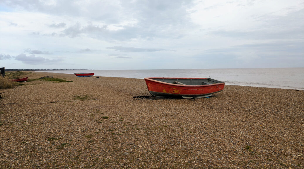 Row boats sitting ashore on Dunwich beach